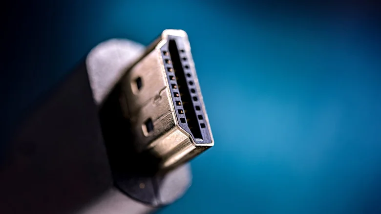 Photo of a black HDMI cable in close-up in front of a blue background.