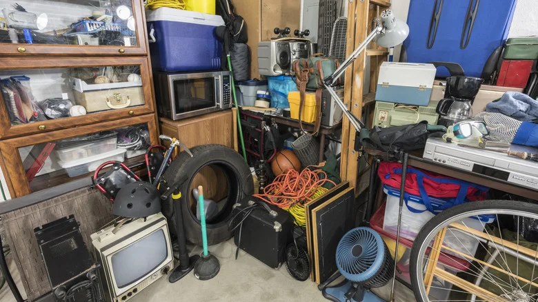 Cluttered storage area featuring a variety of equipment, tools, and vintage electronics.