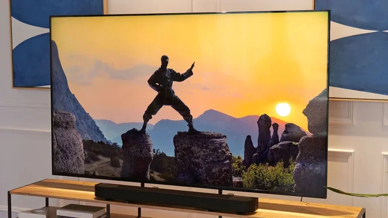 Sony Bravia TV and soundbar on an entertainment center, with the TV showing a person standing on two rocks.