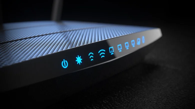 A Wi-Fi router lit up in the darkness, showing various blue icons.