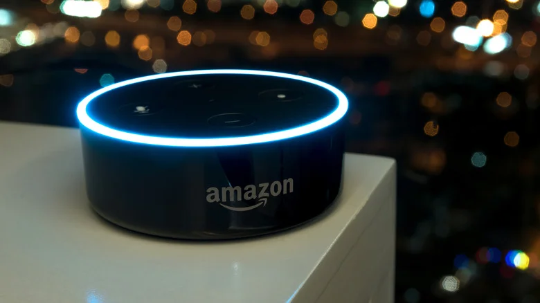 An Amazon Echo dot lit up on a table.